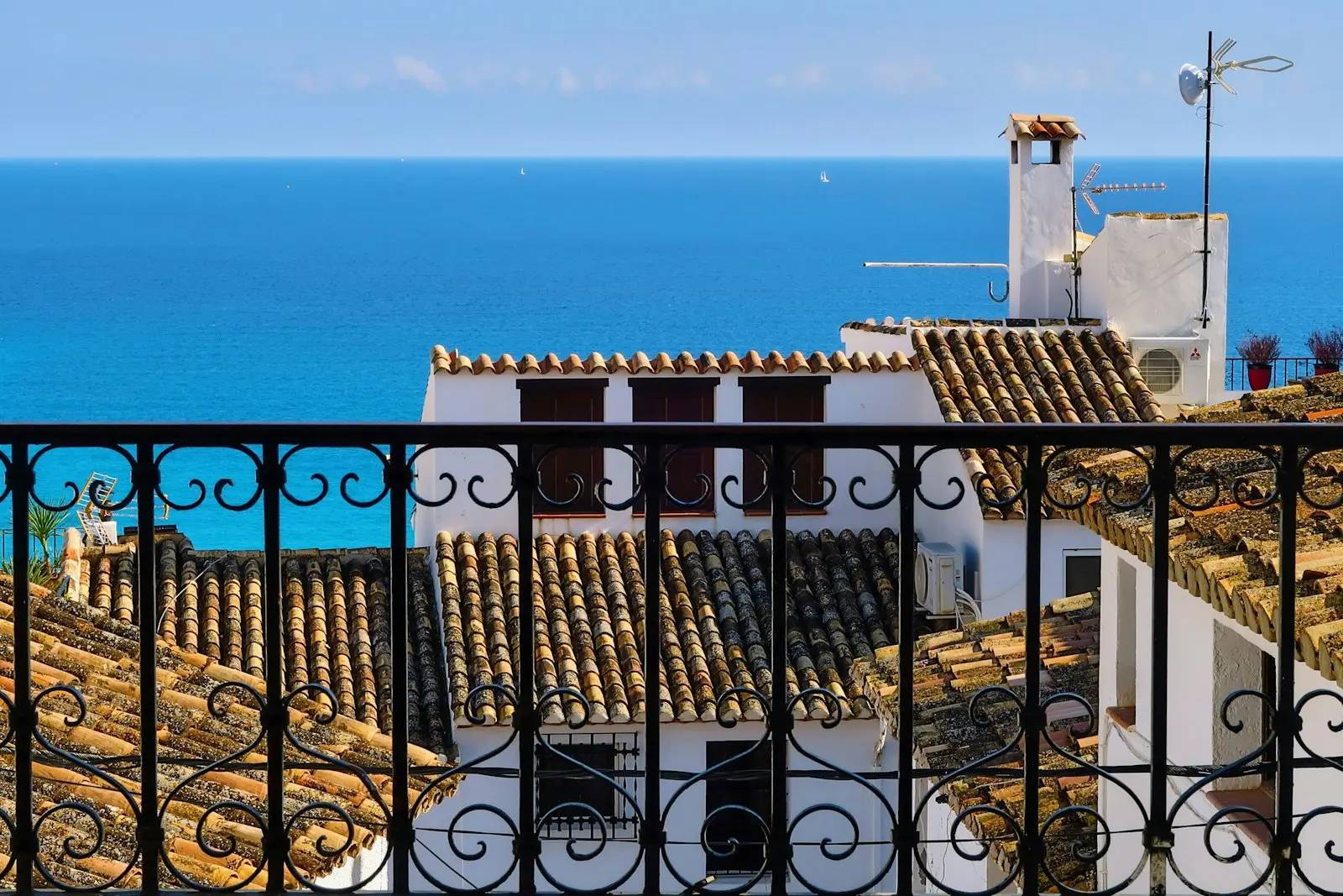 Havsutsikt över tegeltak från en balkong i smidesjärn i Altea, på Costa Blanca