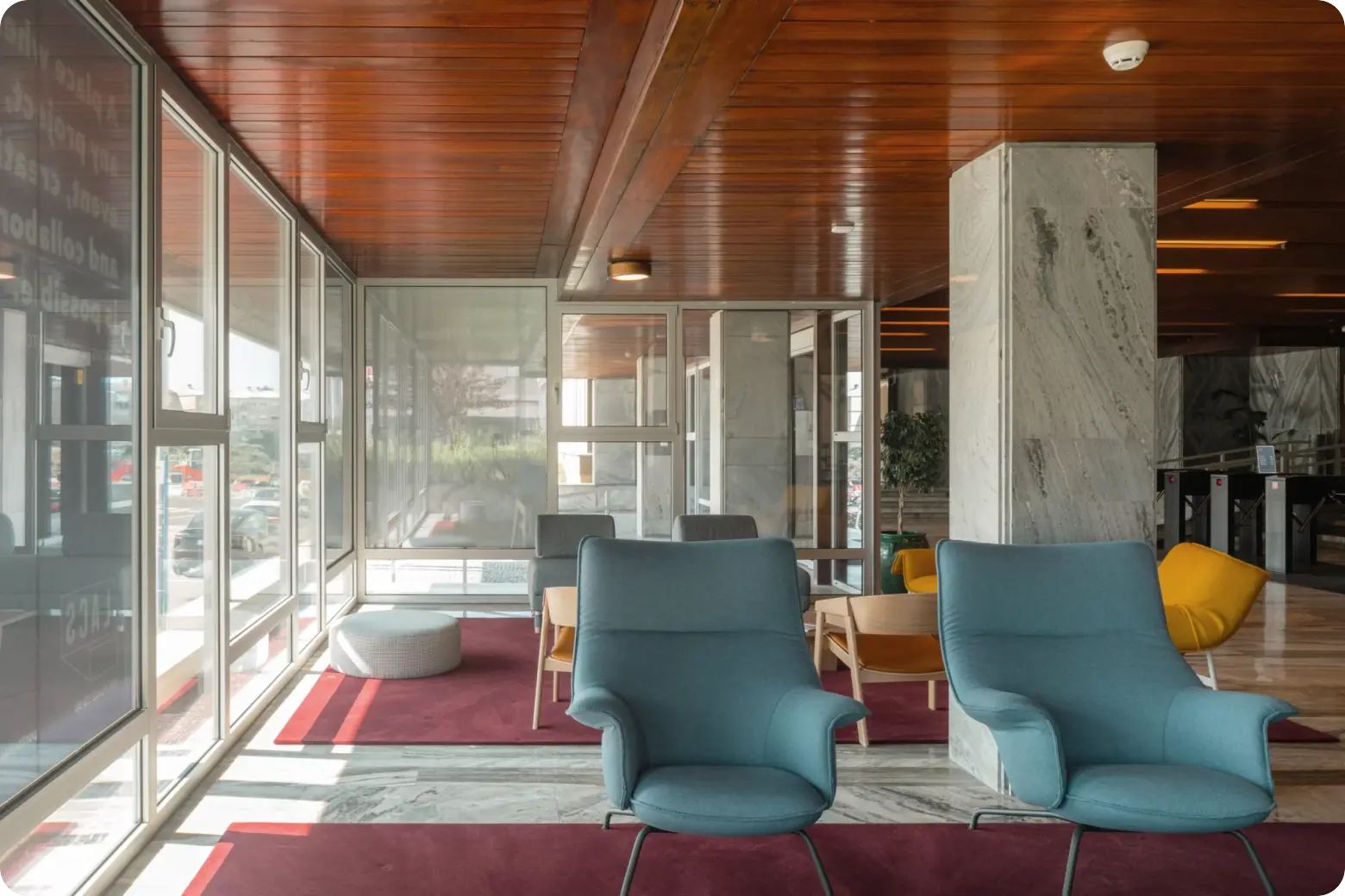 Lounge with blue armchairs and marble columns at LACS Porto in the Boavista Office Center